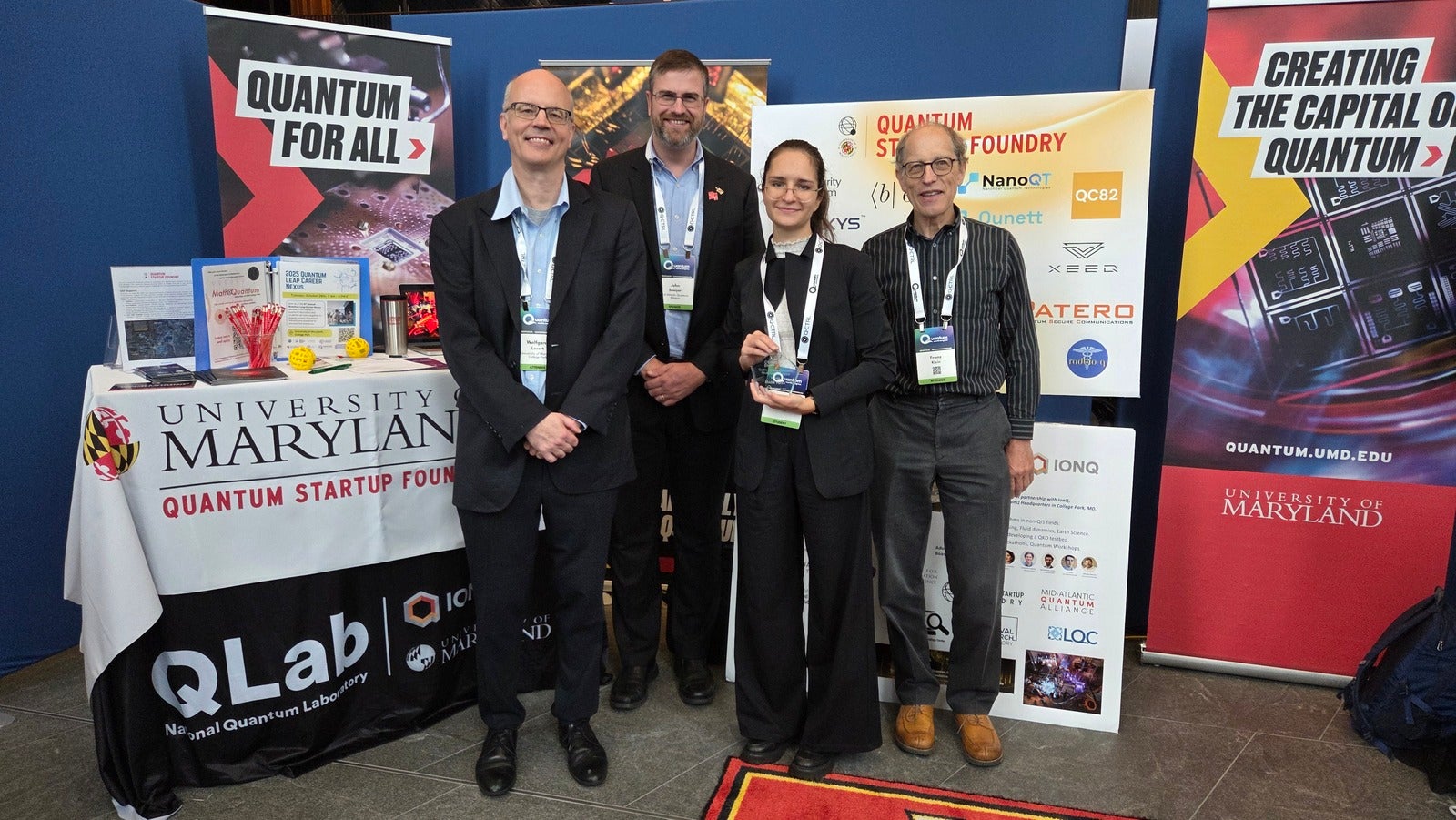 Maria Yuffa together with the proposers of the challenge Wolfgang Losert, John Sawyer, and Franz Klein at the QLab/QSF booth.