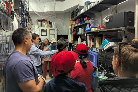 Norbert Linke explains ion trap quantum computing lab to Terp families