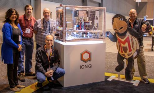 group standing next to quantum computer